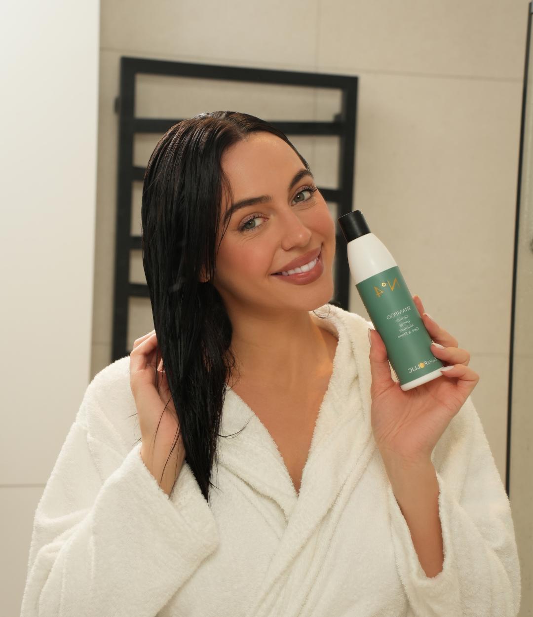 Smiling woman holding SwissFOLLIC N°4 Shampoo